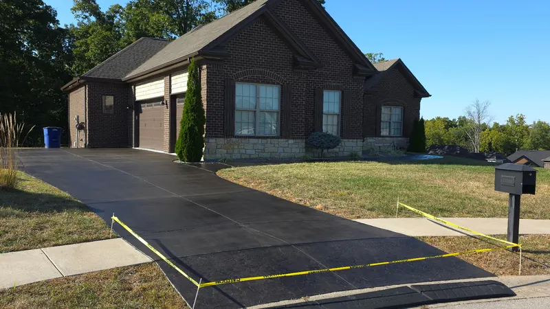 After: concrete driveway at a brick home, cleaned by Meyer Pressure Washing