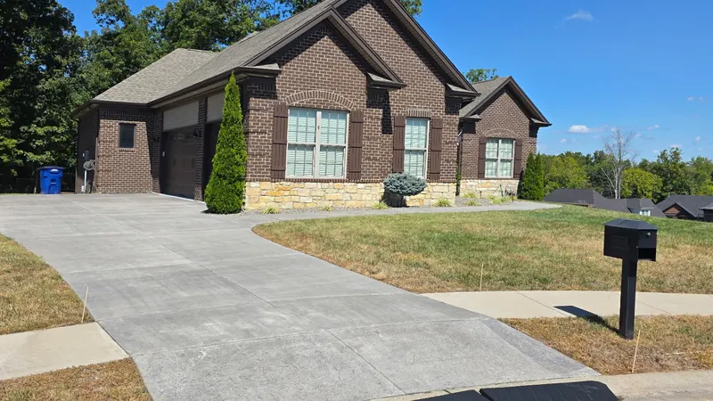 Before: concrete driveway at a brick home