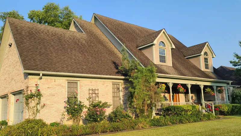 Before: shingle roof on a brick home with dormers